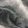 Детайл отблизо: Картина буря в морето: голяма вълна с бяла пяна се разбива в тъмно море под буреносно небе