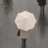 Детайл: белият чадър и жена в бежово палто с черна чанта отблизо Детайл: белият чадър и жена в бежово палто с черна чанта отблизо