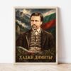 Портрет на Хаджи Димитър в светла дървена рамка, облегнат на бяла стена върху паркет Портрет на Хаджи Димитър в светла дървена рамка, облегнат на бяла стена върху паркет