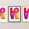 Същата картина с надпис LOVE в бяла, черна и дървена рамка на стена