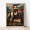 Портрет на Панайот Хитов в светла дървена рамка, облегнат на бяла стена върху паркет Портрет на Панайот Хитов в светла дървена рамка, облегнат на бяла стена върху паркет