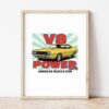 Картина с жълто мускул кар купе и надпис V8 POWER в светла дървена рамка, облегната на бяла стена върху паркет