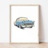 Постер със синьо ретро Chevrolet Bel Air в светла дървена рамка, облегнат на бяла стена върху паркет